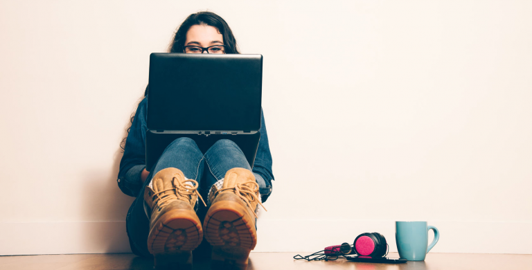 Girl with computer, headphones and cup